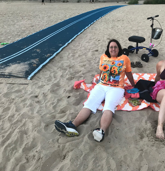 lady sitting on the sand enjoying a beach day