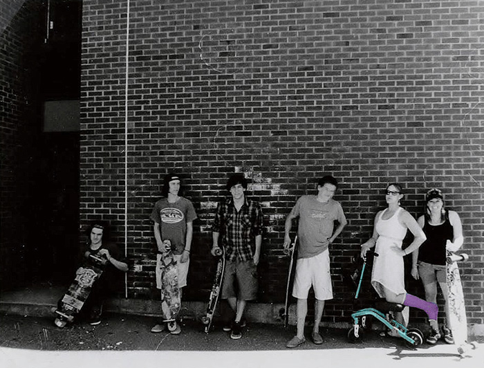 group of college students posing, one of them using a knee scooter