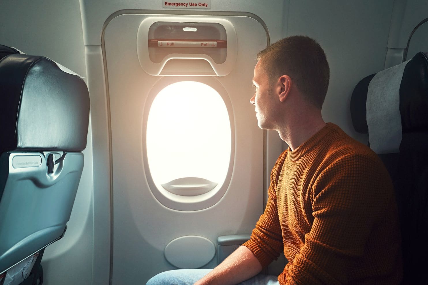 man looking out plane window