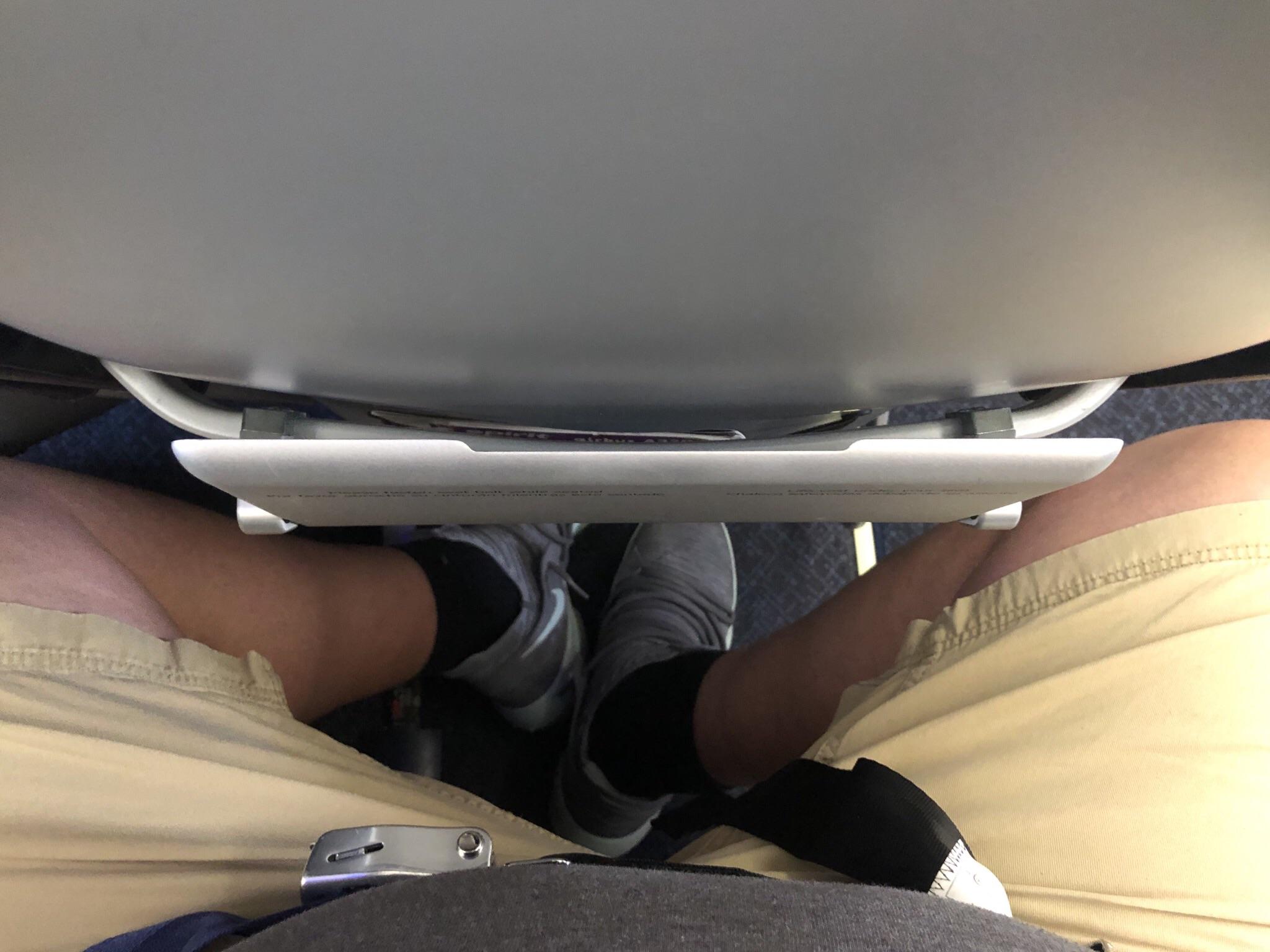 mans legs squished by seat
