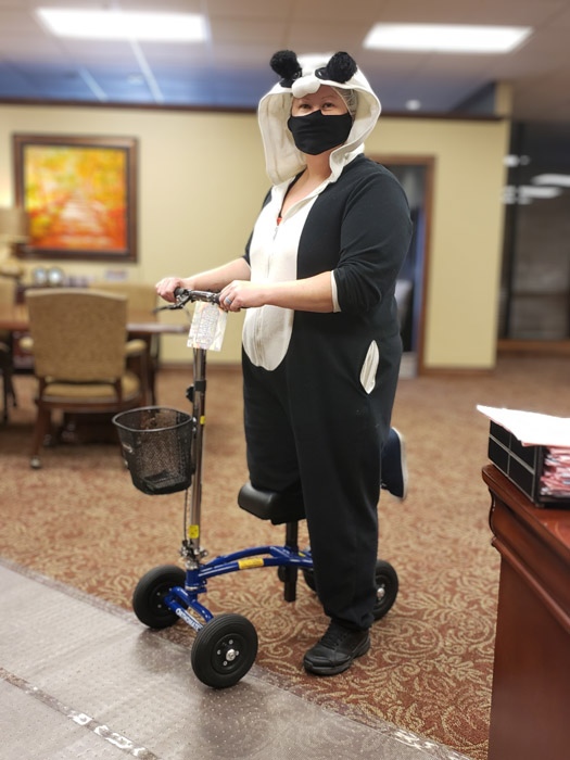 lady dressed in a bear onesie, with an all terrain knee scooter