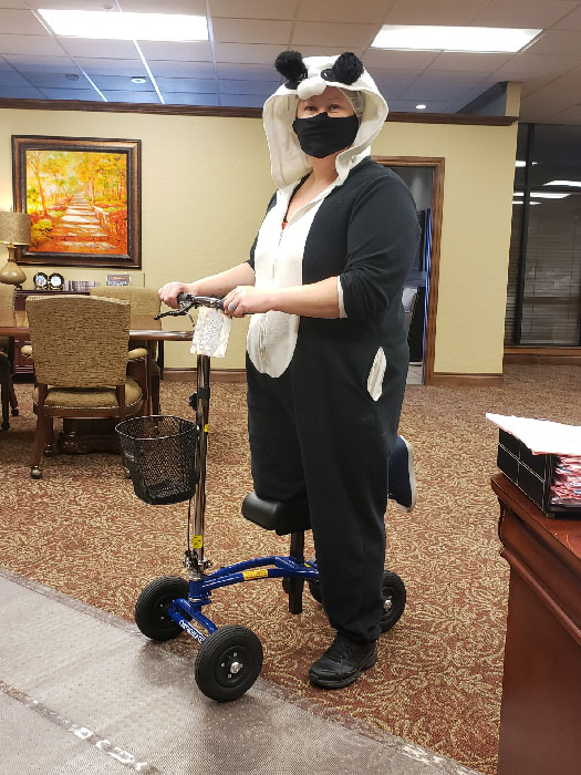 woman with a panda costume riding a knee scooter