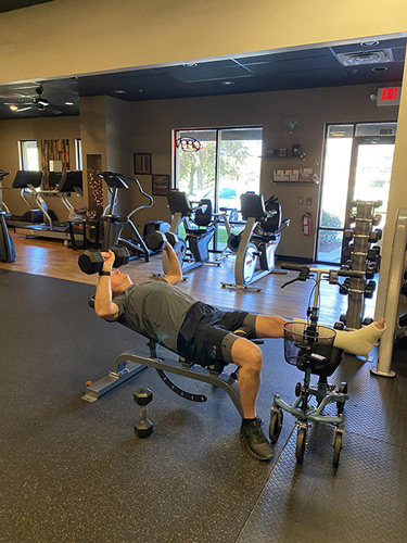 man working out on a knee scooter