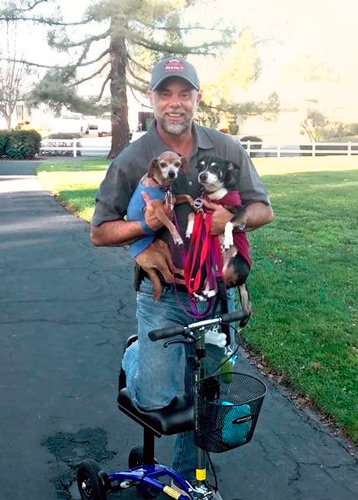 patient holding dogs with knee scooter