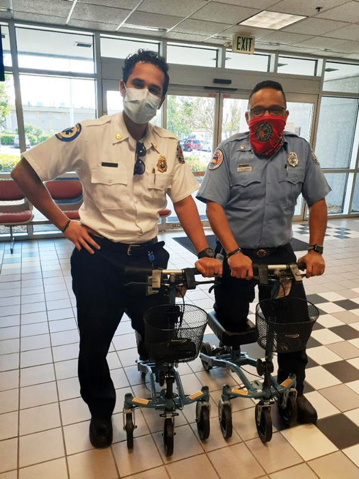 two firefighters using a knee scooter indoors
