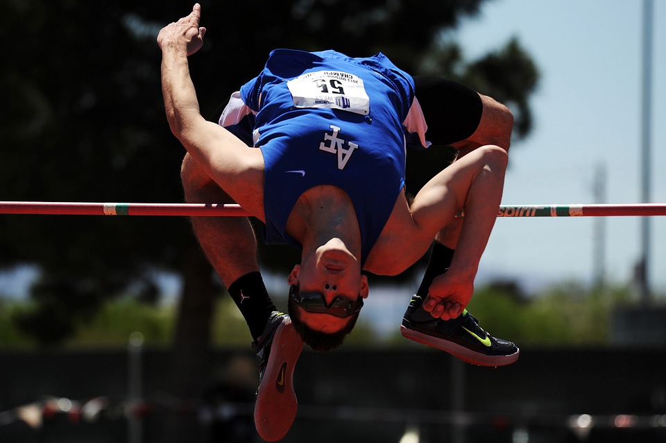 runner jumping over pole