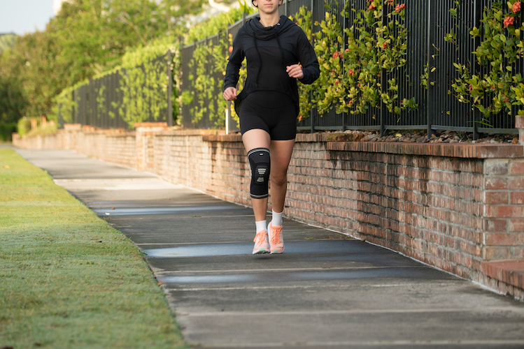 model with knee compression running outdoors