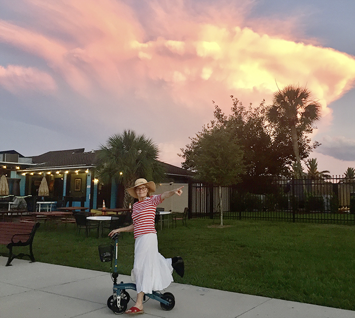 lady walking outdoors with a knee scooter