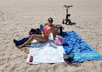 woman in cast on the beach with walker